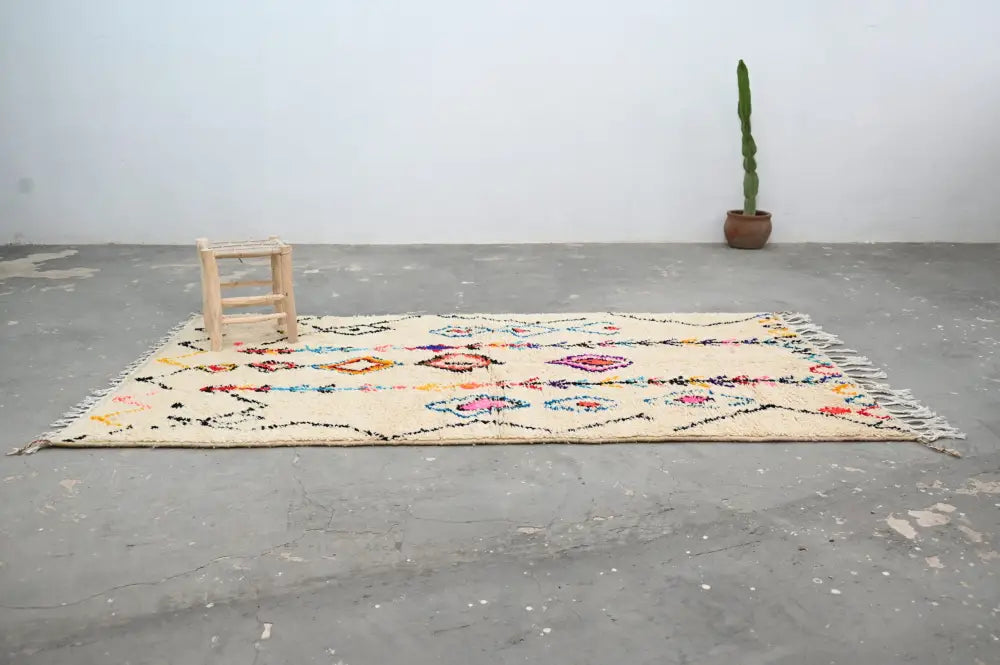 Handmade beige azilal rug with colorful patterns for bedroom