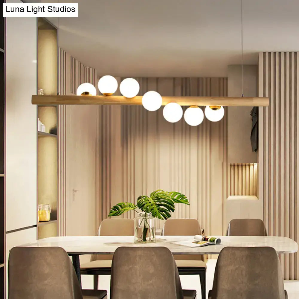 Minimalist beige wood island pendant with globe lights dining room