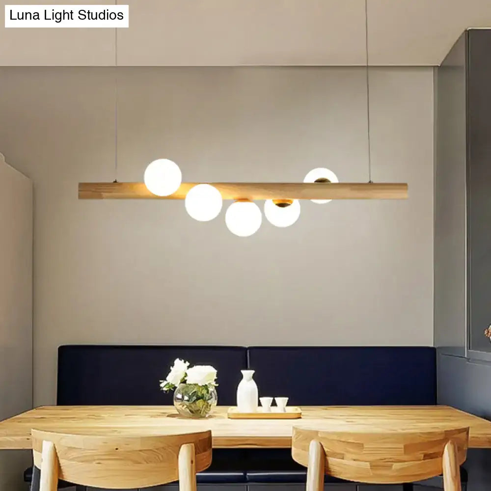 Minimalist beige wood island pendant with globe lights dining room