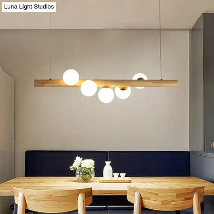 Minimalist beige wood island pendant with globe lights dining room