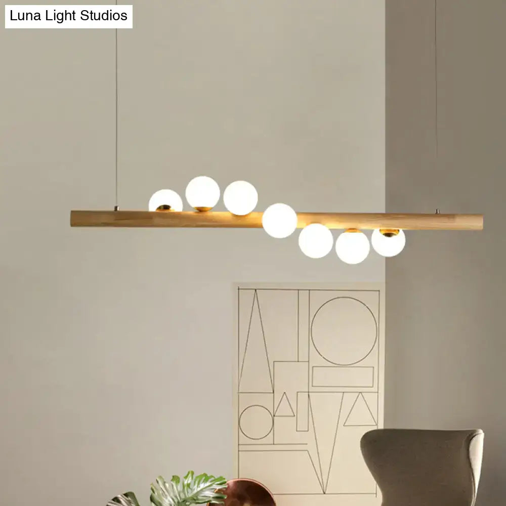 Minimalist beige wood island pendant with globe lights dining room