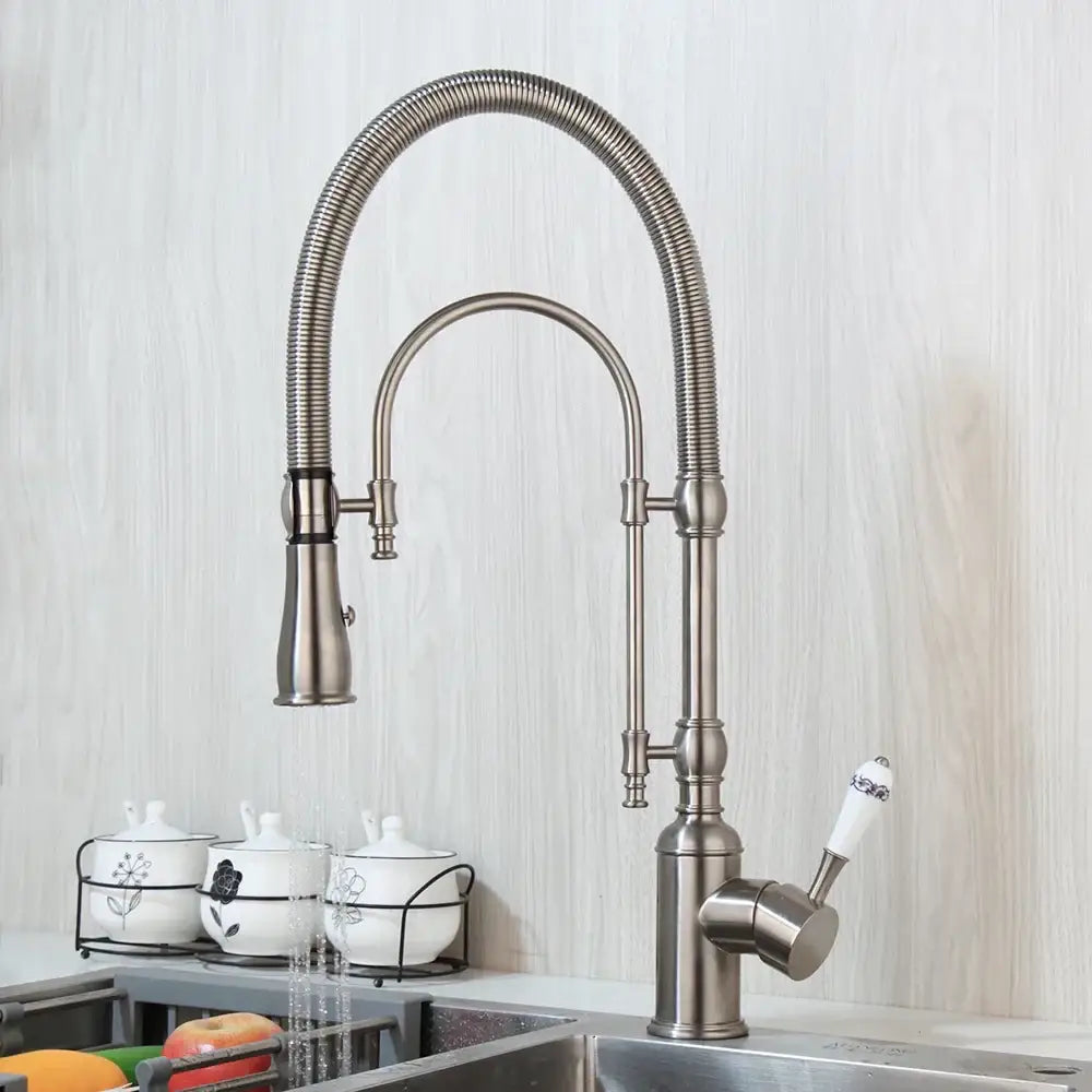 Golden kitchen faucet with white ceramic handle and swivel spout