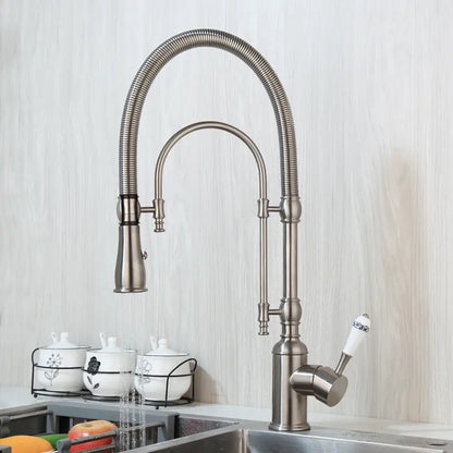 Golden kitchen faucet with white ceramic handle and swivel spout