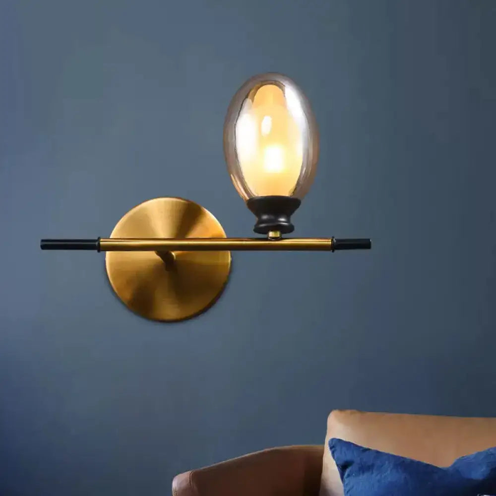 Mid century gold and black wall lamp with amber glass shade bedroom