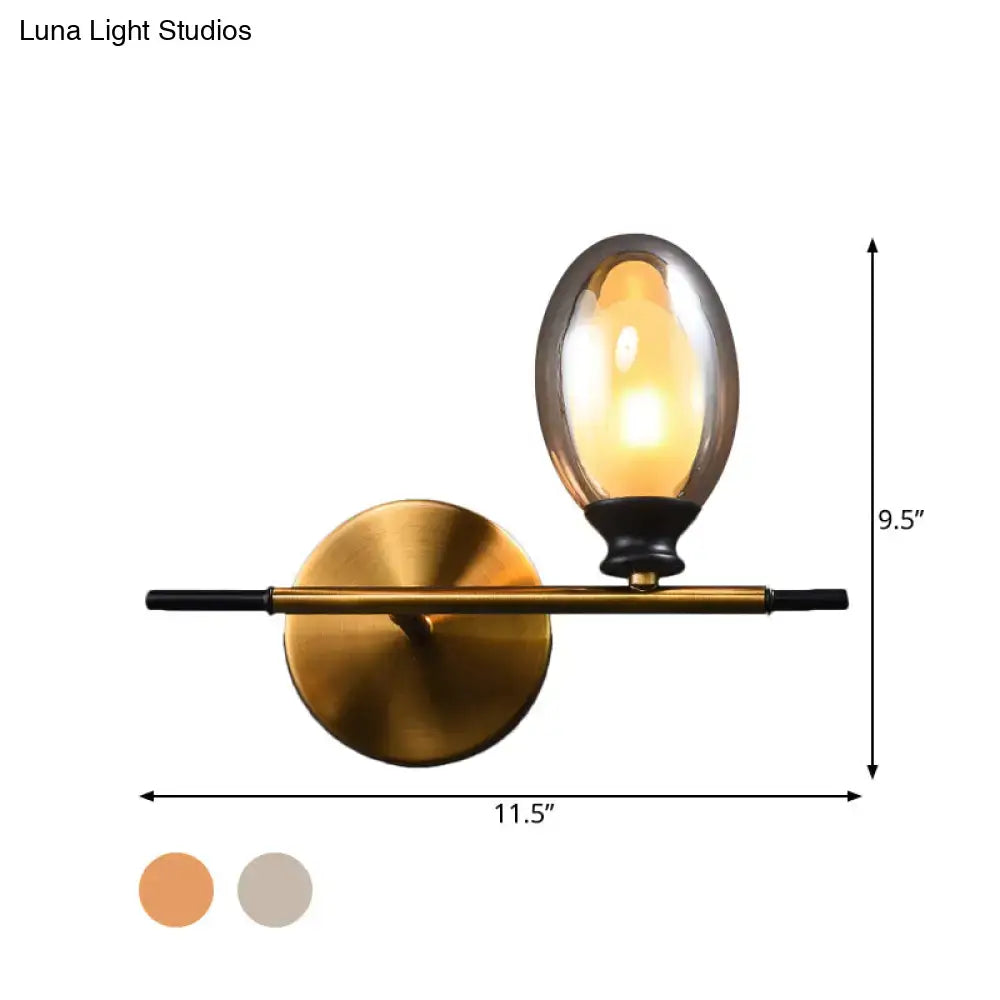Mid century gold and black wall lamp with amber glass shade bedroom