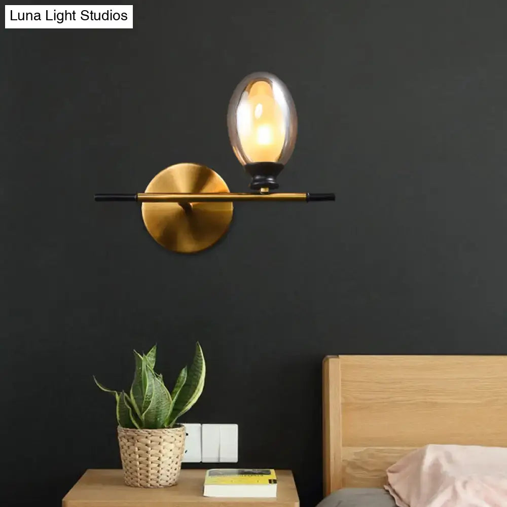 Mid century gold and black wall lamp with amber glass shade bedroom