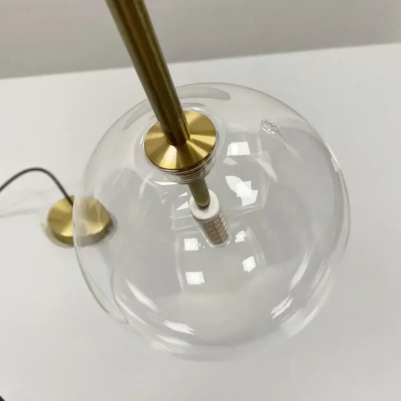 Minimalist brass and clear glass ball pendant light for dining room