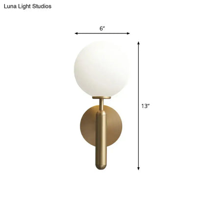 Minimalist brass wall sconce with cream glass shade for living room