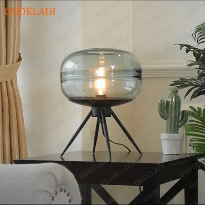 Modern amber glass table lamp with black tripod base for bedroom decor