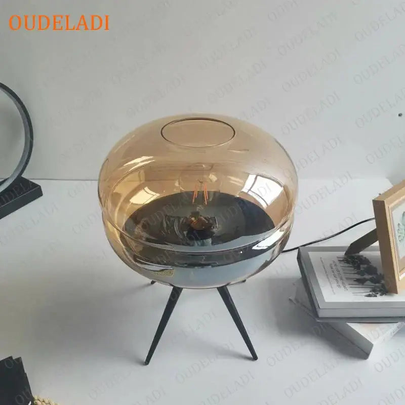 Modern amber glass table lamp with black tripod base for bedroom decor