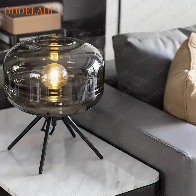 Modern amber glass table lamp with black tripod base for bedroom decor