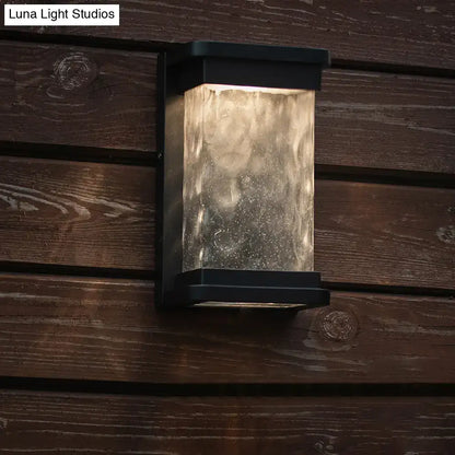 Modern black led outdoor wall sconce with rippled glass cylinder