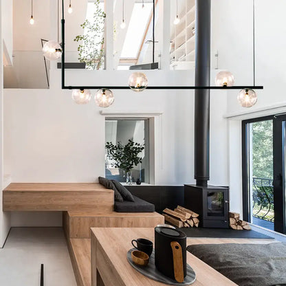 Modern black linear island pendant with glass shade dining room
