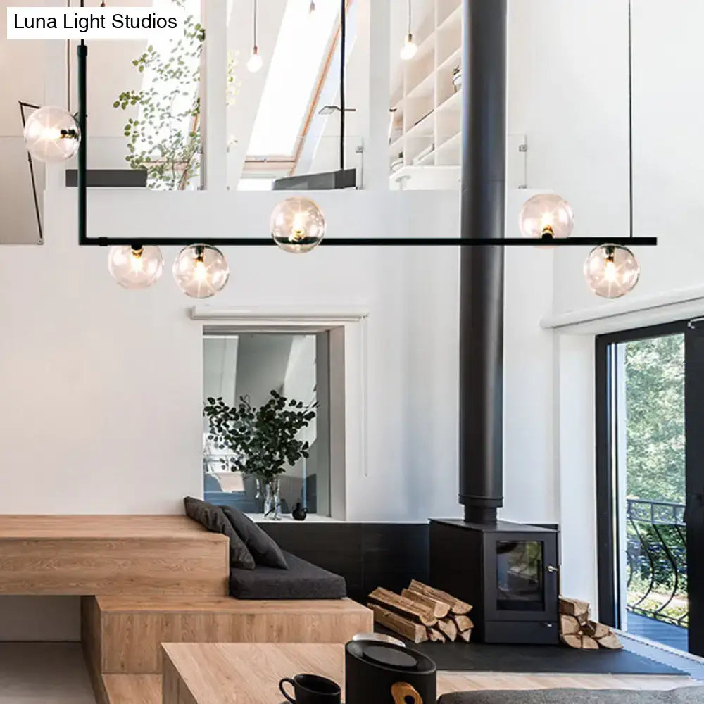 Modern black linear island pendant with glass shade dining room