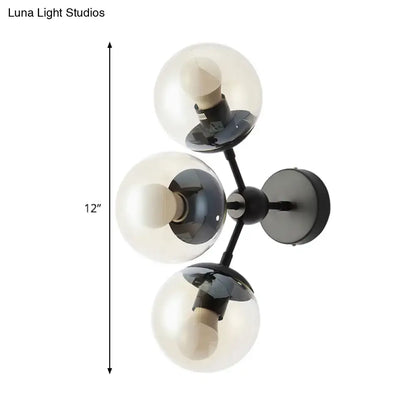 Modern black metal bathroom sconce with three clear glass spheres