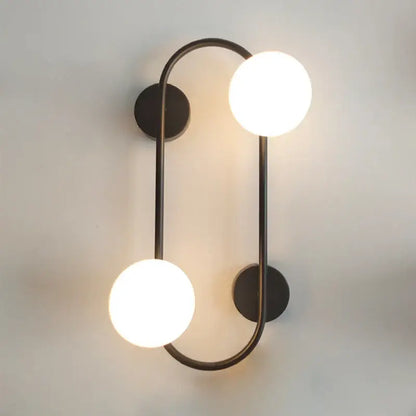 Modern black wall sconce with frosted glass globes – bedroom light