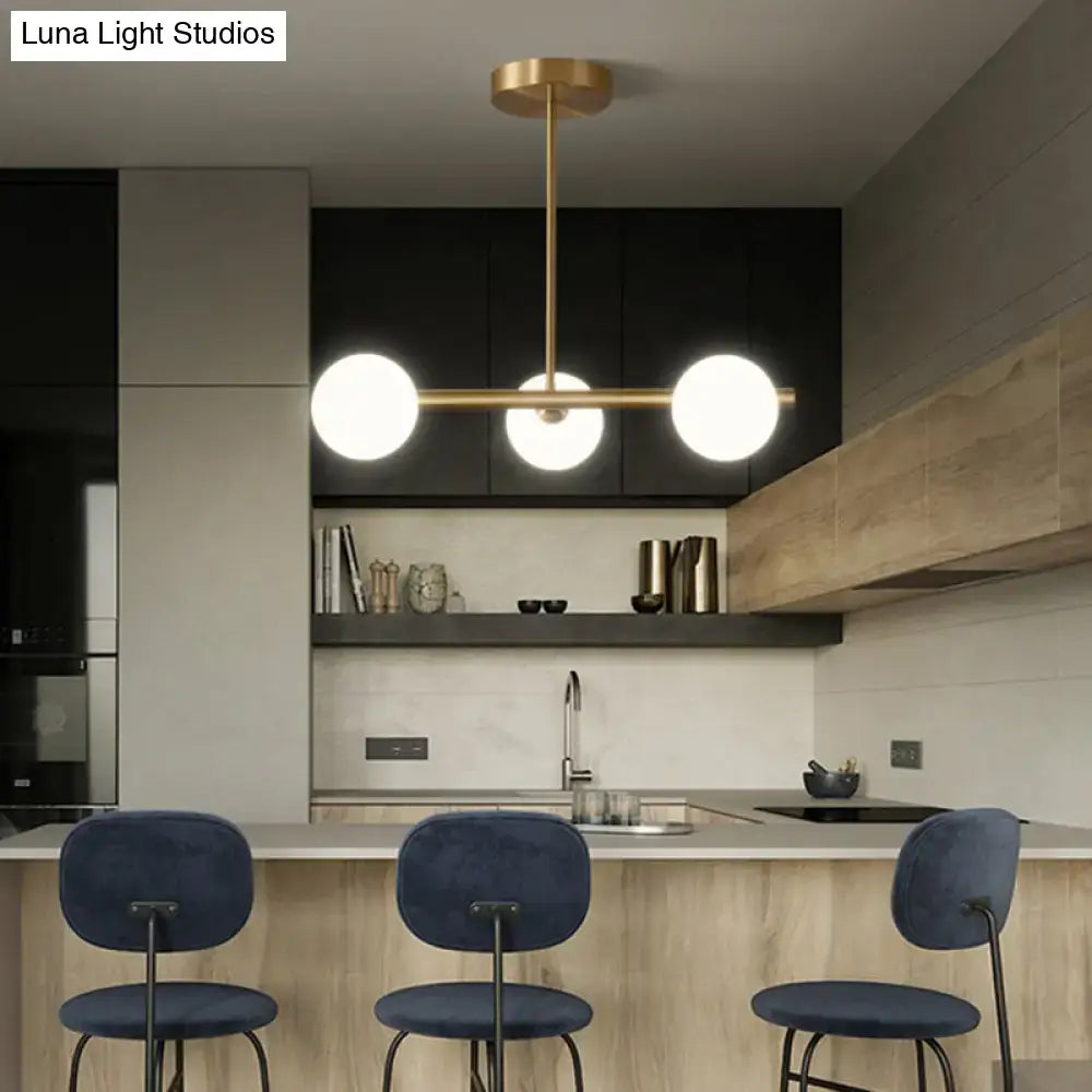Modern brass 5-light pendant light with spherical glass shade dining room