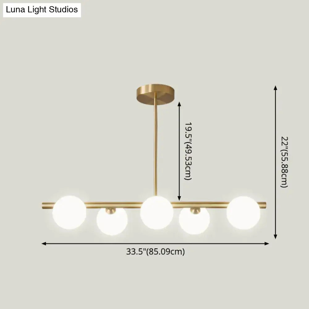 Modern brass 5-light pendant light with spherical glass shade dining room