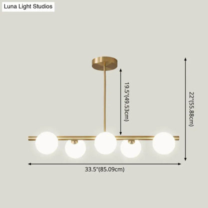 Modern brass 5-light pendant light with spherical glass shade dining room