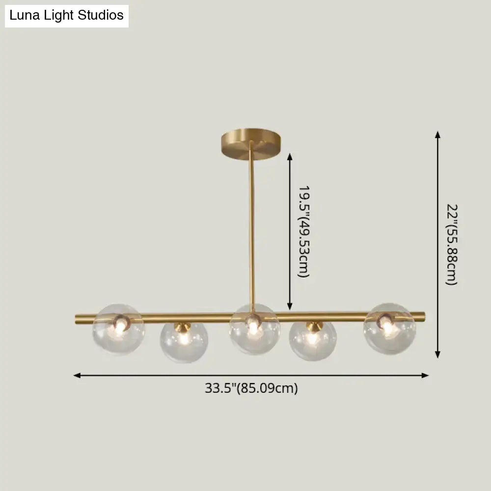 Modern brass 5-light pendant light with spherical glass shade dining room