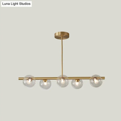 Modern brass 5-light pendant light with spherical glass shade dining room