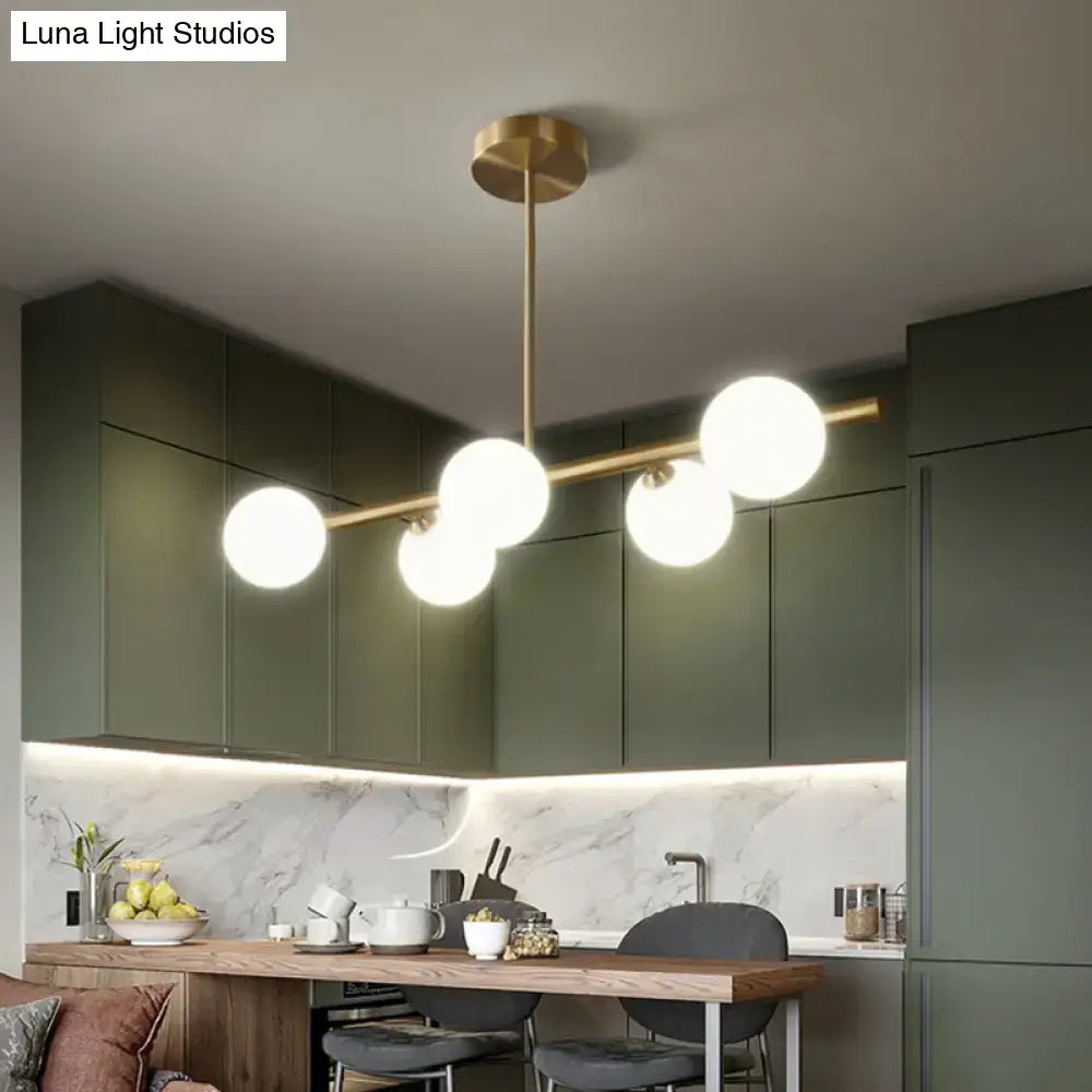 Modern brass 5-light pendant light with spherical glass shade dining room