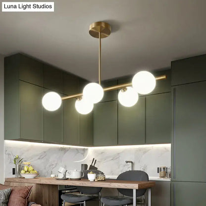 Modern brass 5-light pendant light with spherical glass shade dining room