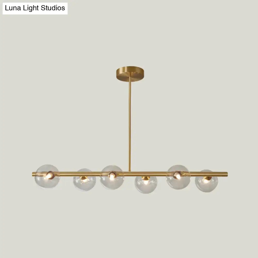 Modern brass 5-light pendant light with spherical glass shade dining room