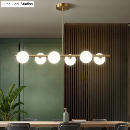 Modern brass 5-light pendant light with spherical glass shade dining room