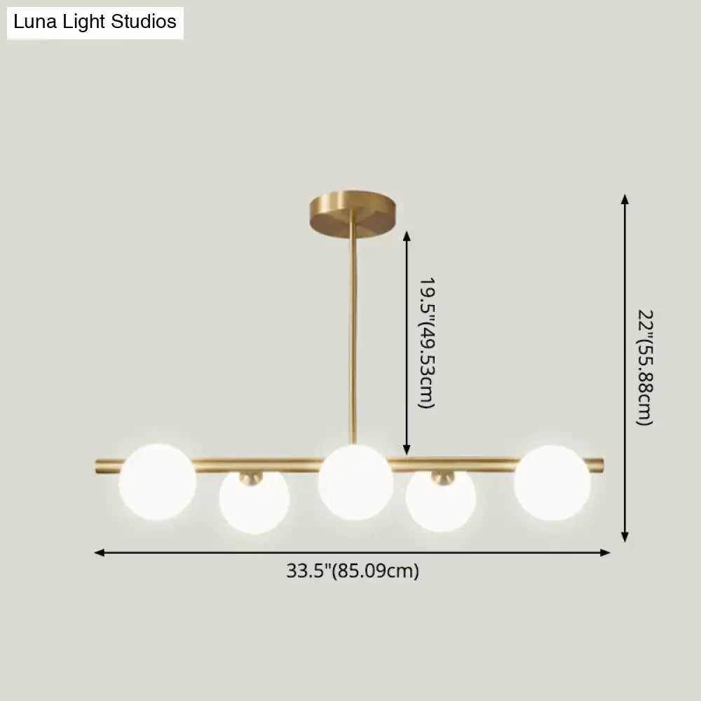 Modern brass 5-light pendant light with spherical glass shade dining room