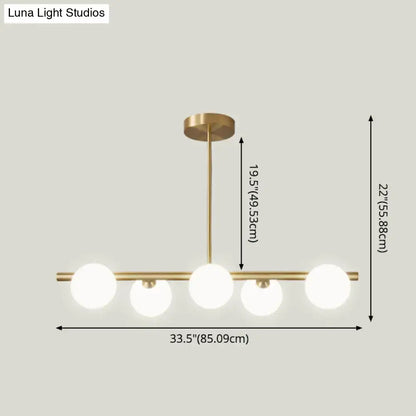 Modern brass 5-light pendant light with spherical glass shade dining room