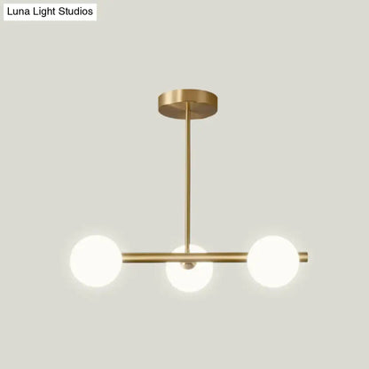 Modern brass 5-light pendant light with spherical glass shade dining room