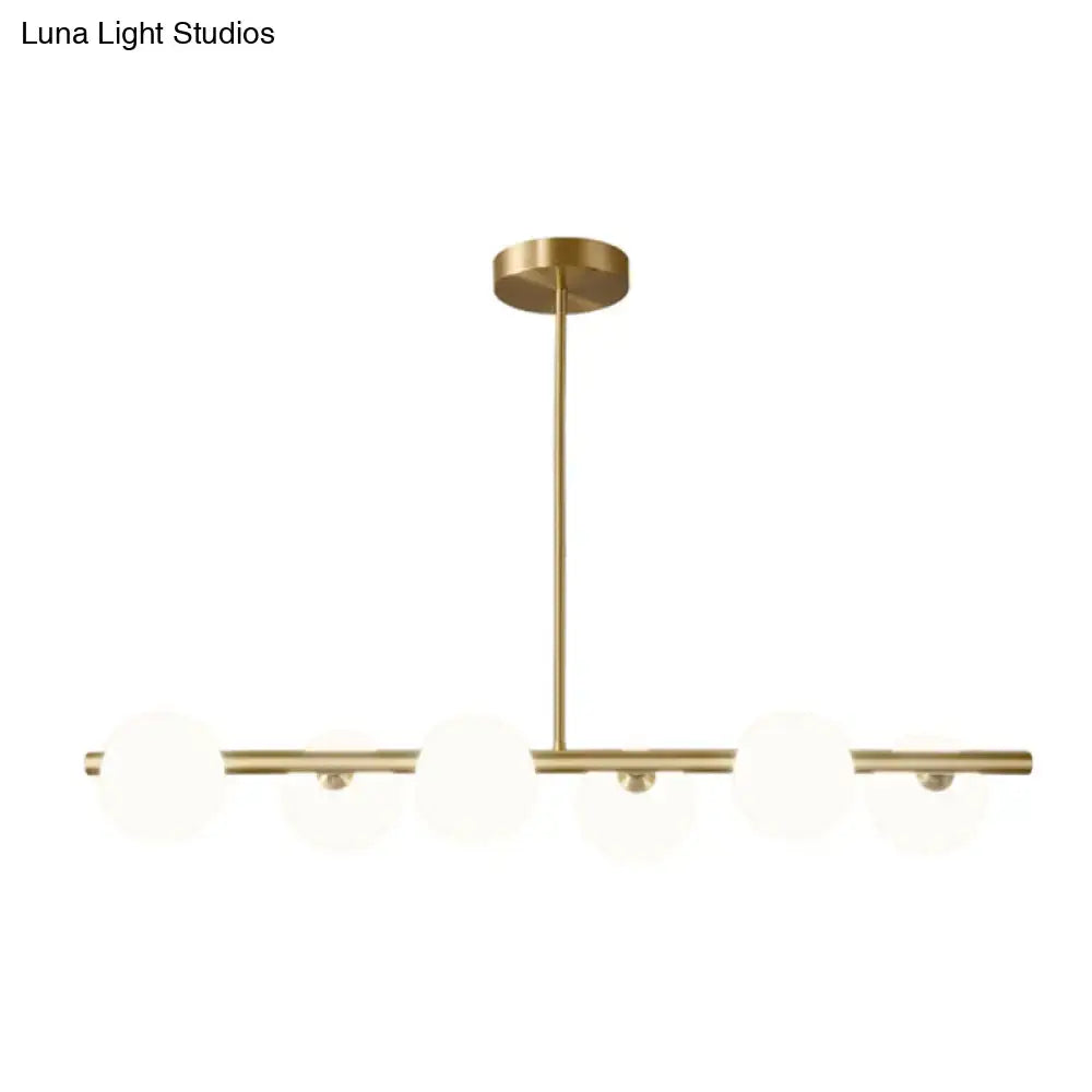Modern brass 5-light pendant light with spherical glass shade dining room