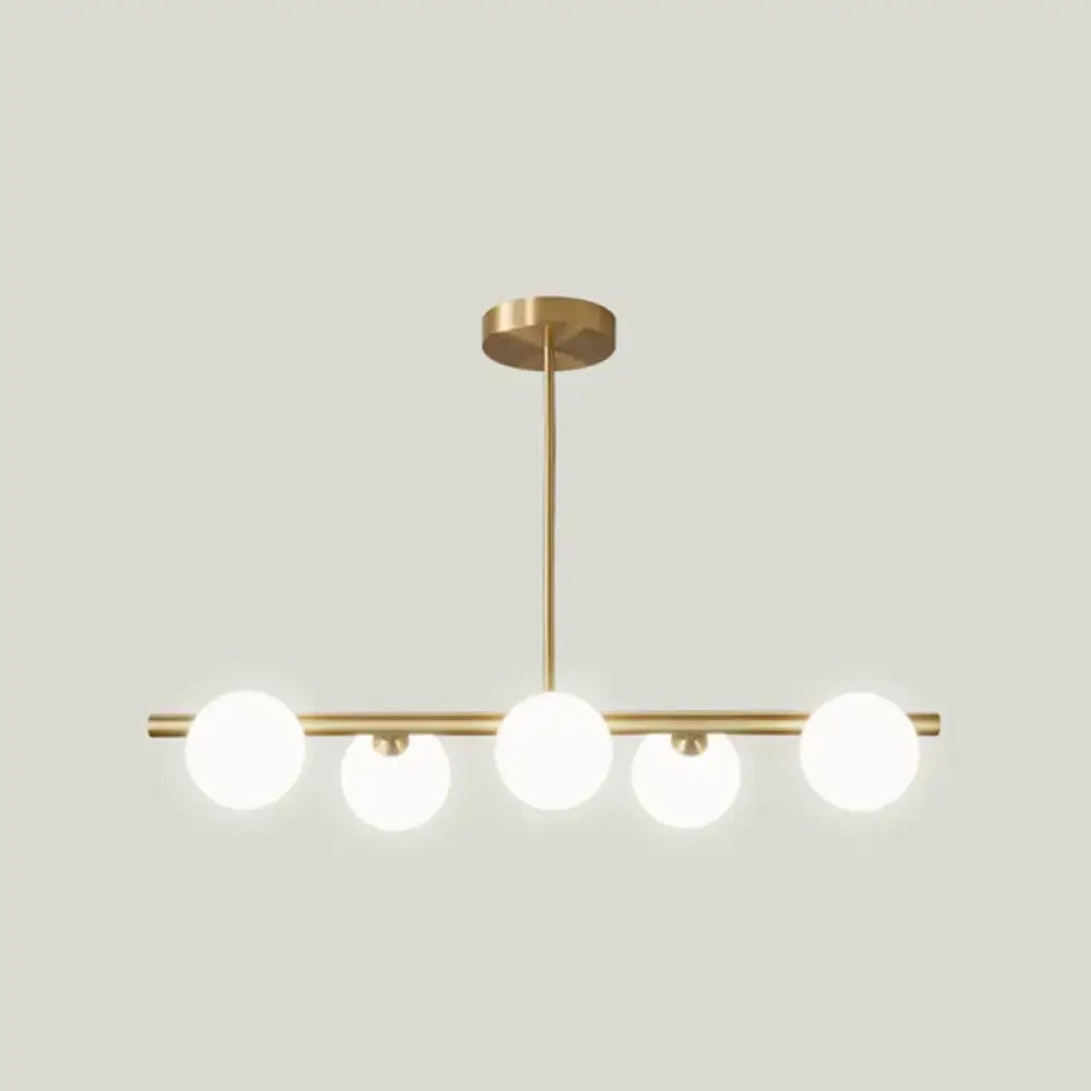 Modern brass 5-light pendant light with spherical glass shade dining room