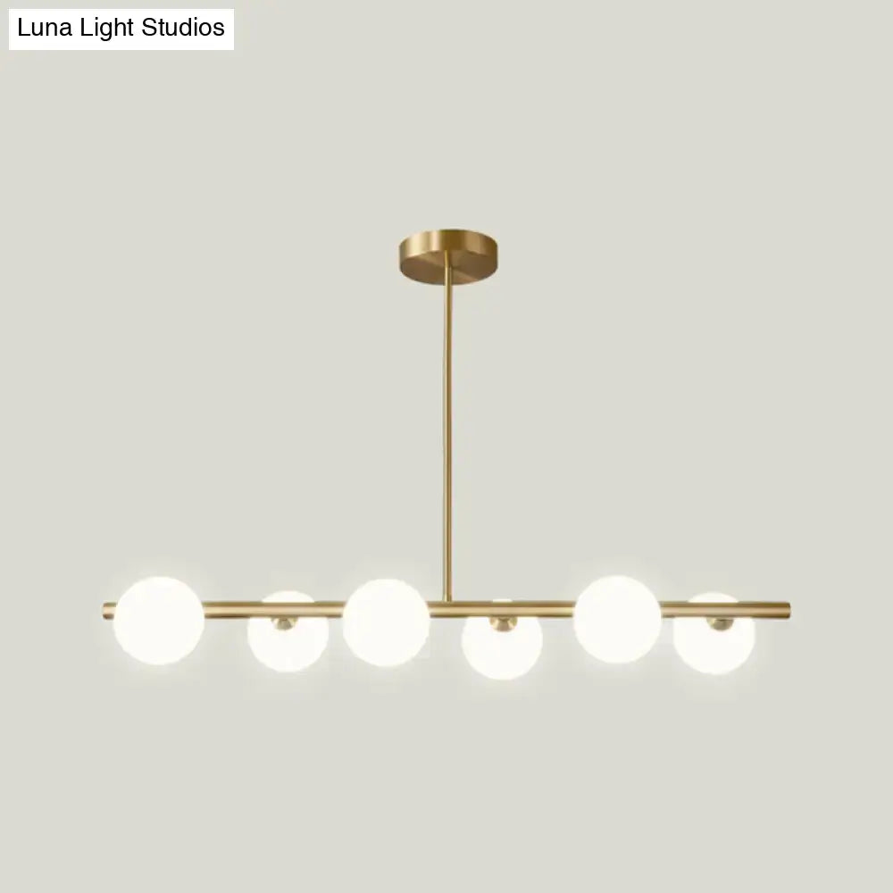 Modern brass 5-light pendant light with spherical glass shade dining room