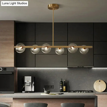 Modern brass 5-light pendant light with spherical glass shade dining room