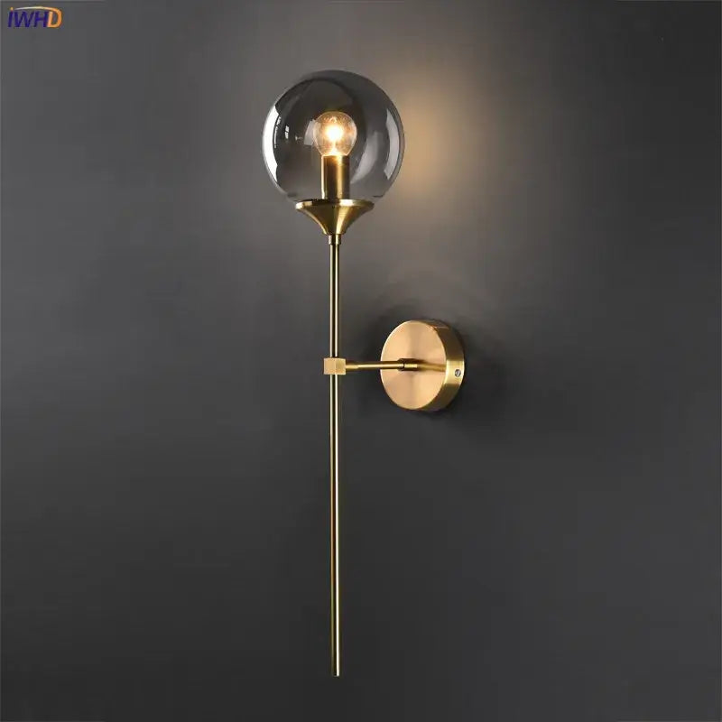 Modern brass and amber glass ball wall lamp for bedroom