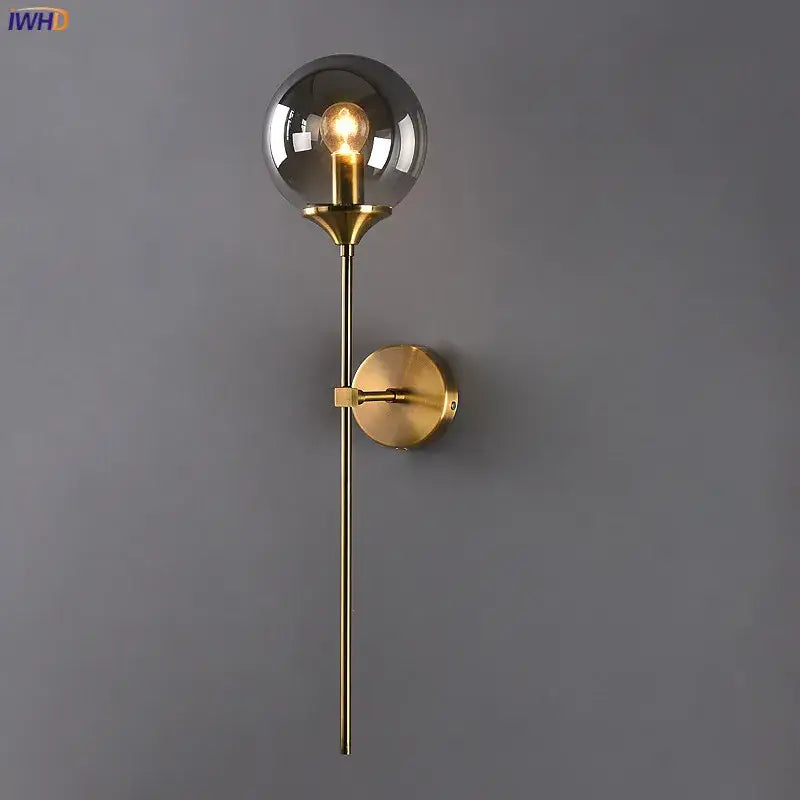 Modern brass and amber glass ball wall lamp for bedroom