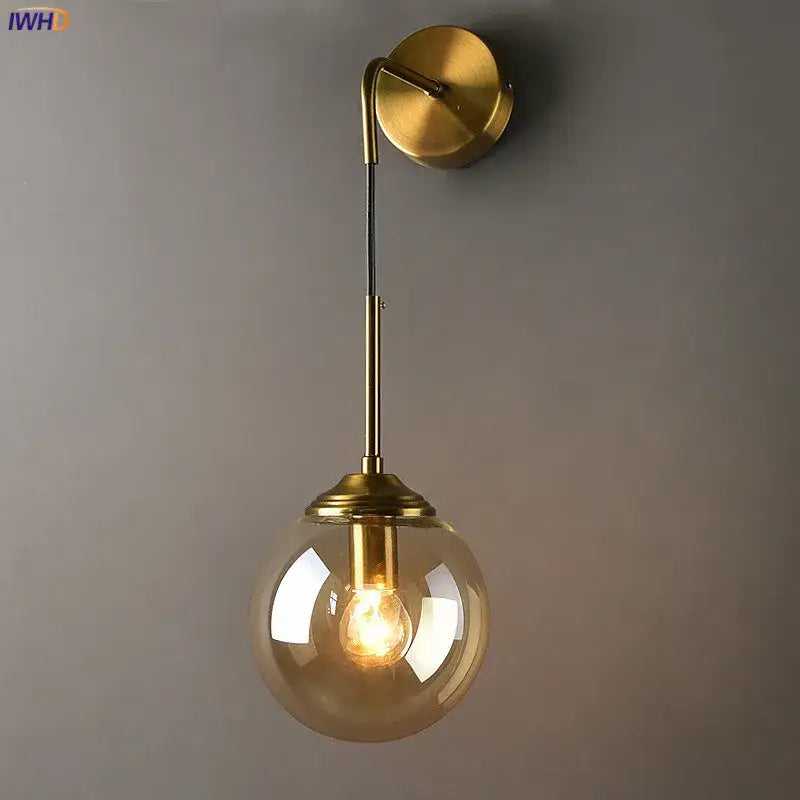 Modern brass and amber glass ball wall lamp for bedroom