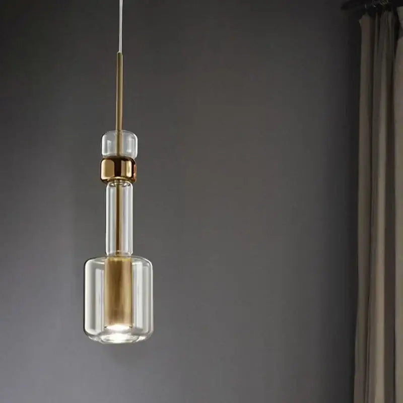Modern brass and black cylindrical glass pendant light for kitchens