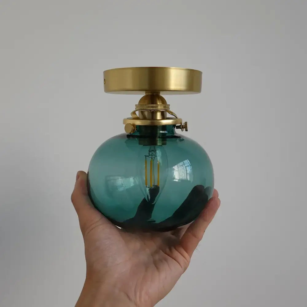 Modern brass and blue glass ball wall sconce with pull chain bedroom