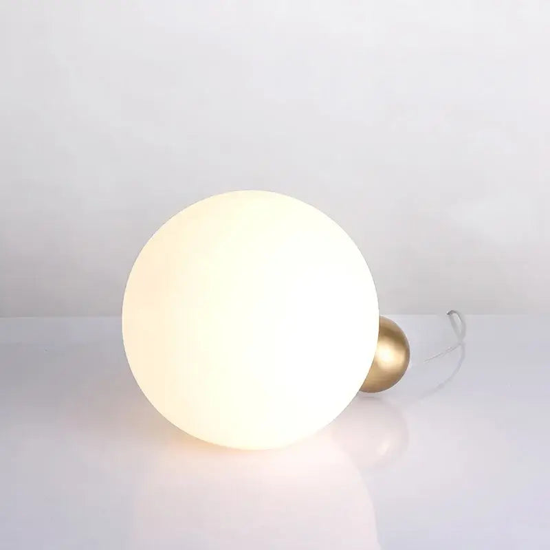 Modern brass and glass desk lamp for bedroom with spherical shade