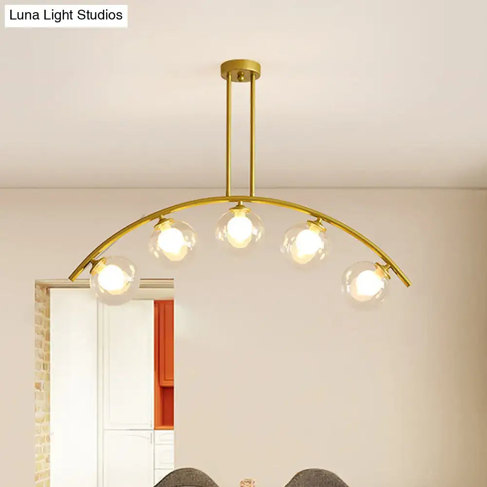 Modern brass arch arm 5-light pendant – dining room glass orb light