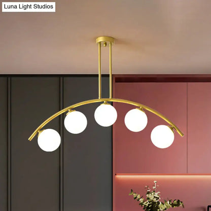 Modern brass arch arm 5-light pendant – dining room glass orb light