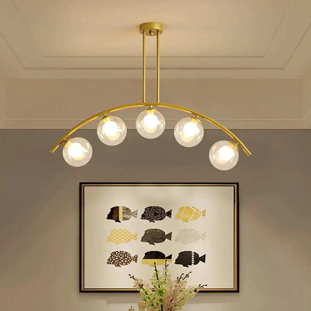 Modern brass arch arm 5-light pendant – dining room glass orb light