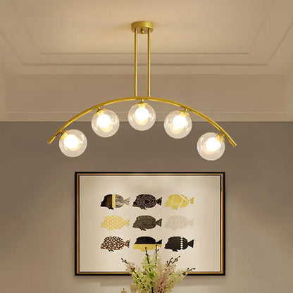 Modern brass arch arm 5-light pendant – dining room glass orb light