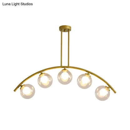 Modern brass arch arm 5-light pendant – dining room glass orb light