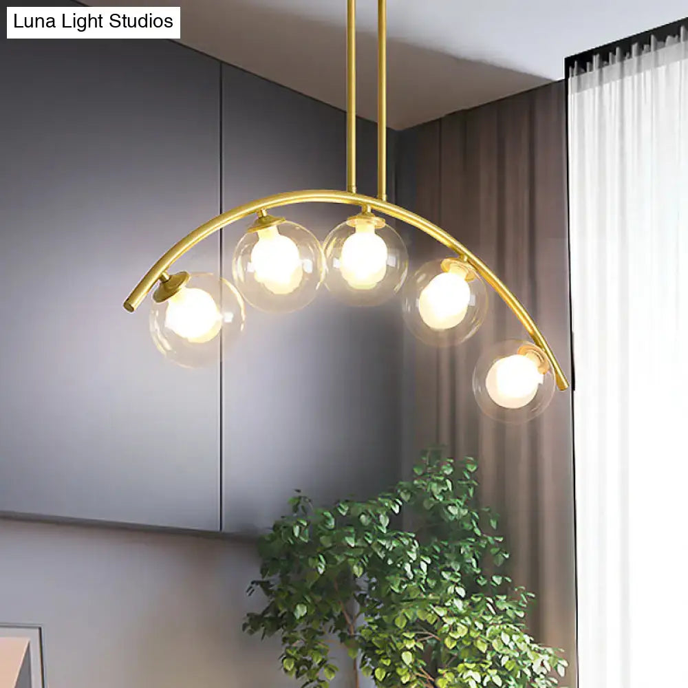 Modern brass arch arm 5-light pendant – dining room glass orb light