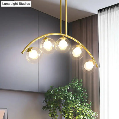 Modern brass arch arm 5-light pendant – dining room glass orb light