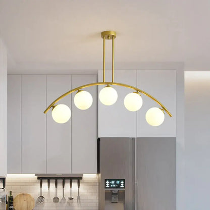 Modern brass arch arm 5-light pendant – dining room glass orb light